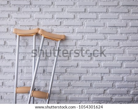 crutch on the white brick wall