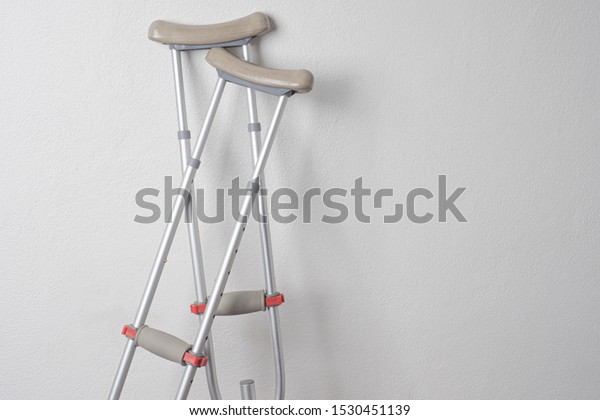 Crutches. Fractured legs. Crutches as a sign of\
disability. Symbol of disability. Rehabilitation in case of injury.\
Concept - workplace injury. Life with disabilities. Personal\
injury. Injuries. 