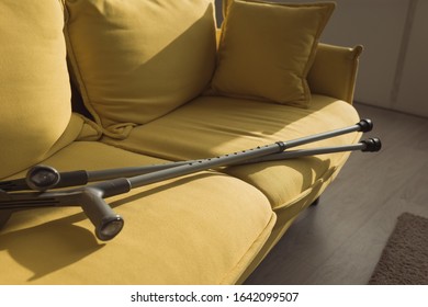 Crutches On Yellow Couch With Sunlight