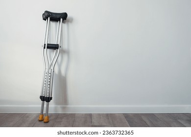 crutches stand near a white wall with copyspace