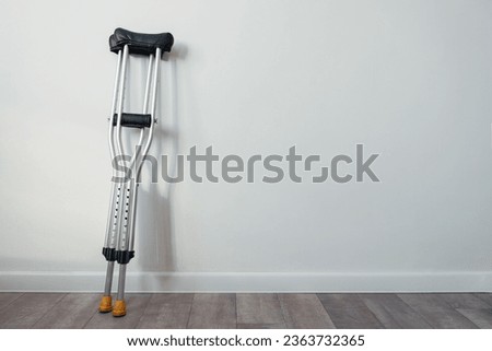 crutches stand near a white wall with copyspace