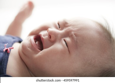 Crying Asian Chinese Baby Girl Lying On Bed
