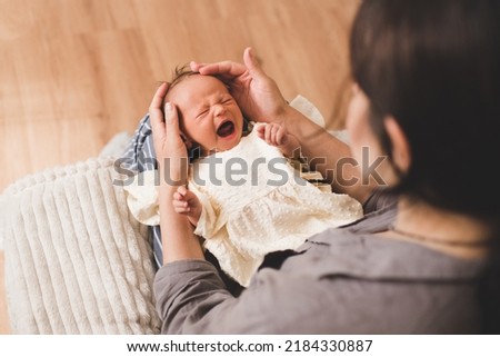 Crying baby girl wake up on mother hands in room closeup. Woman with infant girl. Motherhood. Childhood.