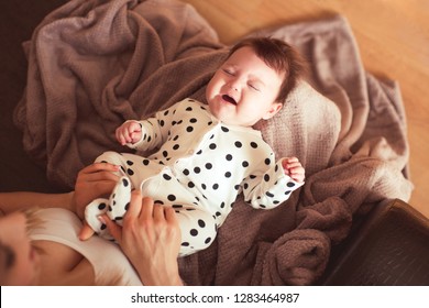 Crying Baby On Mother Hands In Room. Motherhood. Stomach Ache. 