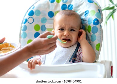 Crying baby refusing to eat anymore porridge and convincing his parent to stop feeding him 