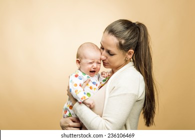 Crying child with mother studio shot on beige background