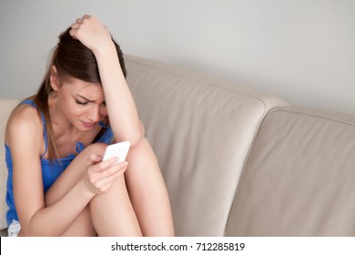 Crying Depressed Teen Girl Holds Phone Sitting On Sofa, Frustrated Young Woman Looking At Cell Feeling Hopeless After Reading Bad Message, Breaking Up, Scared Of Threatening, Mobile Abuse, Copy Space