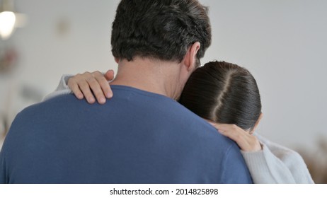 Crying Hispanic Woman Hugging Man at Home