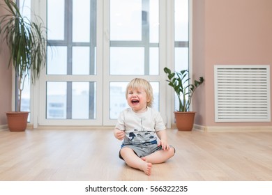 Crying Little Cute Child On The Floor At Home. 2 Years Old Toddler Or Baby Sadness.