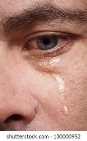 Crying man with tears in eye closeup