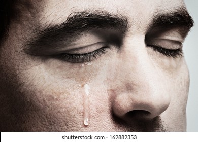 Crying man with tears on face closeup