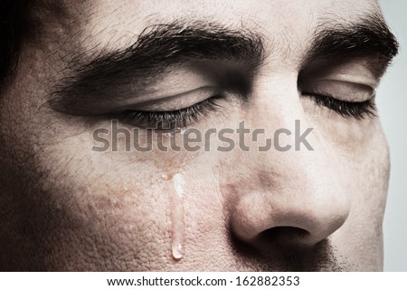 Crying man with tears on face closeup