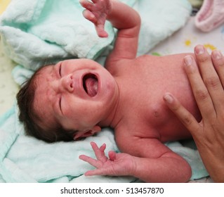 Crying Newborn Infant With Mother's Hand