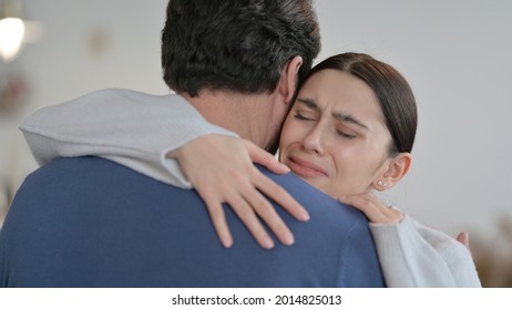 Crying Spanish Woman Hugging Man at Home