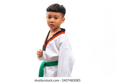 Llorando por las lágrimas. Niños retratos karate artes marciales. uniforme de taekwondo con cinturón verde. Retrato de un escolar tailandés aislado en una pancarta de fondo blanco. Concepto de formación en deporte de acción