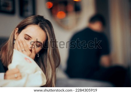 
Crying Woman Discovering Proof of Adultery Deciding to Divorce her Husband. Suffering wife holding a lipstick-stained shirt of her cheating boyfriend
