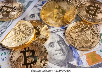 Crypto Bitcoin One dollar bitcoin, virtual money and one hundred dollar banknotes. Bitcoins on US dollars. Dollar to bitcoin exchange. Background with crypto bitcoins, and dollars. Golden bitcoin. 