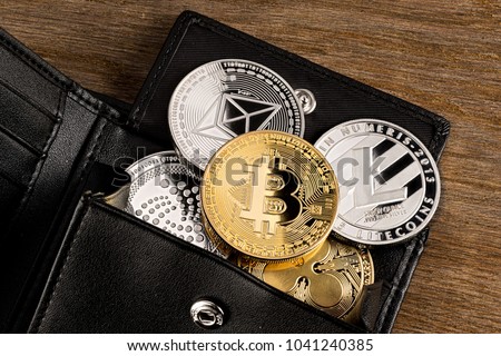 crypto currency coin in leather wallet on wide wood wooden background bitcoin ethereum litecoin iota ripple