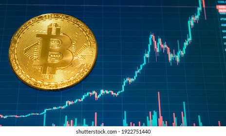 Crypto currency Golden Bitcoin isolated on black background. Photo of coin in front of mobile phone with chart of bitcoin value. Blockchain technology, bitcoin mining concept. - Shutterstock ID 1922751440