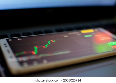 Crypto data chart at smartphone. Online trading is an activity of buying and selling shares with the aim of making a profit from the difference between the initial purchase price and the selling price