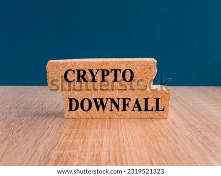 Crypto downfall symbol. Concept words Cryptos downfall on brick blocks. Beautiful wooden table dark blue background. Business and crypto downfall concept. Copy space.