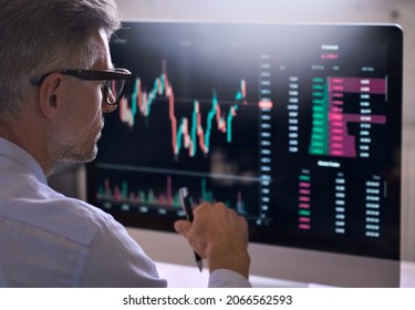 Crypto trader investor analyst broker using pc computer analyzing online cryptocurrency exchange stock market indexes charts investing money profit in trading platform stockmarket  Over shoulder view 
