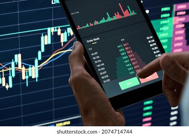 Crypto trader investor broker holding finger on buy or sell button executing financial stock trade market trading order thinking of cryptocurrency or shares assets investment risks and profit concept.