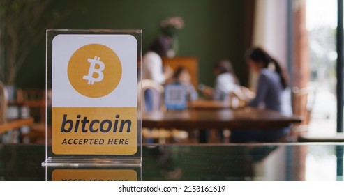Cryptocurrency Bitcoin ethereum blockchain accepted sign logo on modern SME coffee shop table with defocus blurred background of customer eating enjoy meal. Virtual shopping digital money service. - Shutterstock ID 2153161619