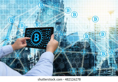 Cryptocurrency, Blockchain And Bitcoin Concept. Distributed Ledger Technology. Man Holding Tablet , Block Chain  Icons With Smart Building Background. Blue Tone