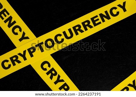 Cryptocurrency caution, warning and danger concept. Yellow barricade tape with word in dark black background.