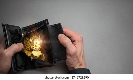 Cryptocurrency coin bitcoin in a black wallet. Bitcoin accumulation, trading sell and buy concept. Cryptocurrency saving symbol.