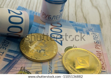 Cryptocurrency coins lying on the russian ruble banknotes. Business concept of new virtual money