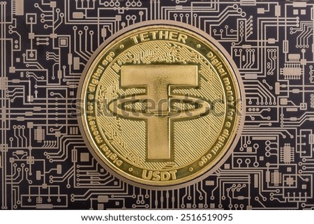 Cryptocurrency concept. A macro shot of TETHER cryptocurrency coin on top of a black printed PCB circuit.