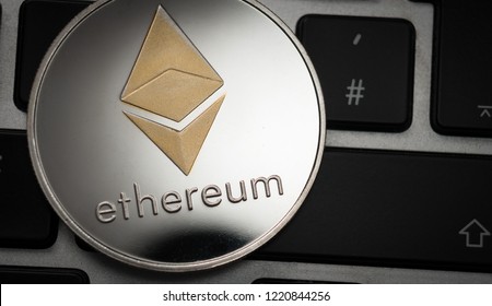 Cryptocurrency Ethereum coin on computer laptop keyboard. Finance, investment and money concept