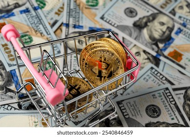 Cryptocurrency golden bitcoin coins in little shopping trolley on US 100 dollars bills background, close up. Digital money and bitcoin concept - Powered by Shutterstock - Get 15% off with code: PIKWIZARD15