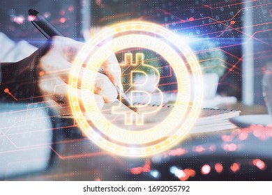 Cryptocurrency hologram, bitcoin, ico theme over hands taking notes background. Concept of blockchain. Multi exposure - Shutterstock ID 1692055792