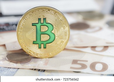 Cryptocurrency physical green bitcoin coin over the euro money.