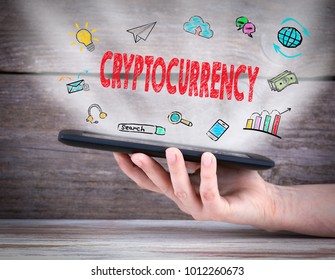 cryptocurrency. Tablet computer in the hand. Old wooden background