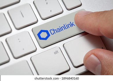Cryptocurrency trading concept: Male hand pressing computer key with Chainlink Link logo. Cryptocurrency mining, trading, market concept.