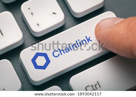 Cryptocurrency trading concept: Male hand pressing computer key with Chainlink | Link logo. Cryptocurrency mining, trading, market concept.