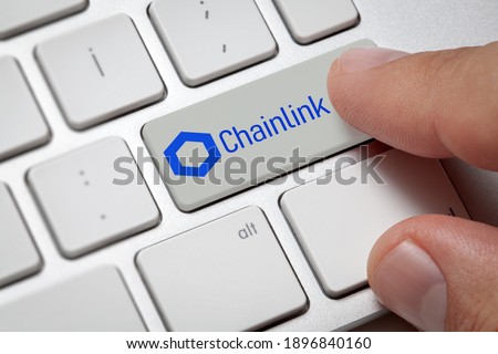 Cryptocurrency trading concept: Male hand pressing computer key with Chainlink Link logo. Cryptocurrency mining, trading, market concept.