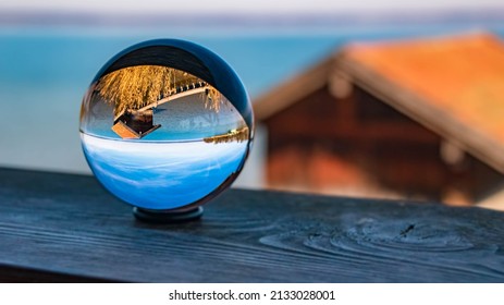 Crystal ball alpine landscape shot with a fisherman´s hut at the famous Chiemsee, Chieming, Chiemgau, Bavaria, Germany