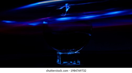 a crystal ball on a rectangular object with blue waves on black background