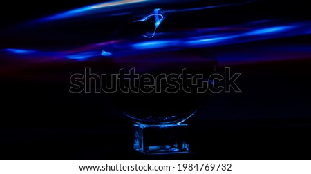 a crystal ball on a rectangular object with blue waves on black background