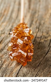 Crystal Brown Rock Sugar Candy On A Stick Close Up (macro) - Vintage Wood As Background.