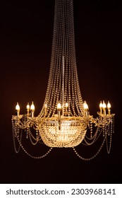 Crystal chandelier shines in the dark, warm light
