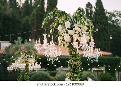 Crystal Chandeliers And Garlands Decorate The Wedding Dinner Outside Among The Trees.
