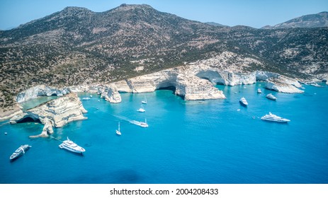 Crystal clear sea in the Greek islands. Milos boats anchored in Kleftiko Beach in the Cyclades.