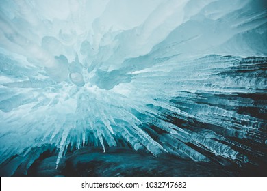 Crystal clear sharp icicles hanging down in frozen cave, lake Baikal, Olkhon island, Siberia, Russia. Beautiful winter wallpaper.
