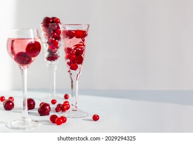 Crystal Glasses Of Pink Gin Or Champag Infused With Cranberry, Set Of Glasses Of Spirits Drinks With Berries, Cherry Liquor Or Any Red Alcoholic Cocktail Banner With Space For Text